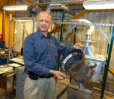 Ashok Gadgil holds stove equipment at Berkeley Lab's facility.